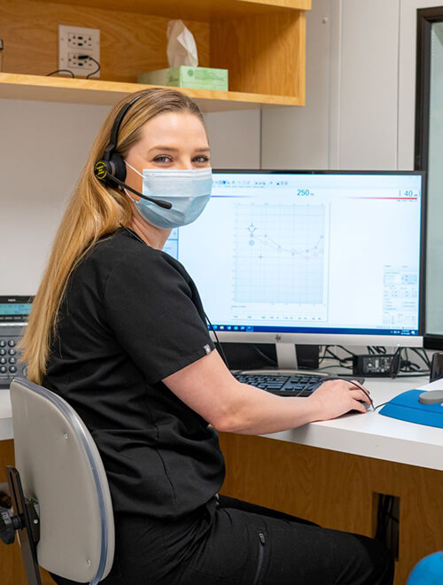 audiologist next to computer chart